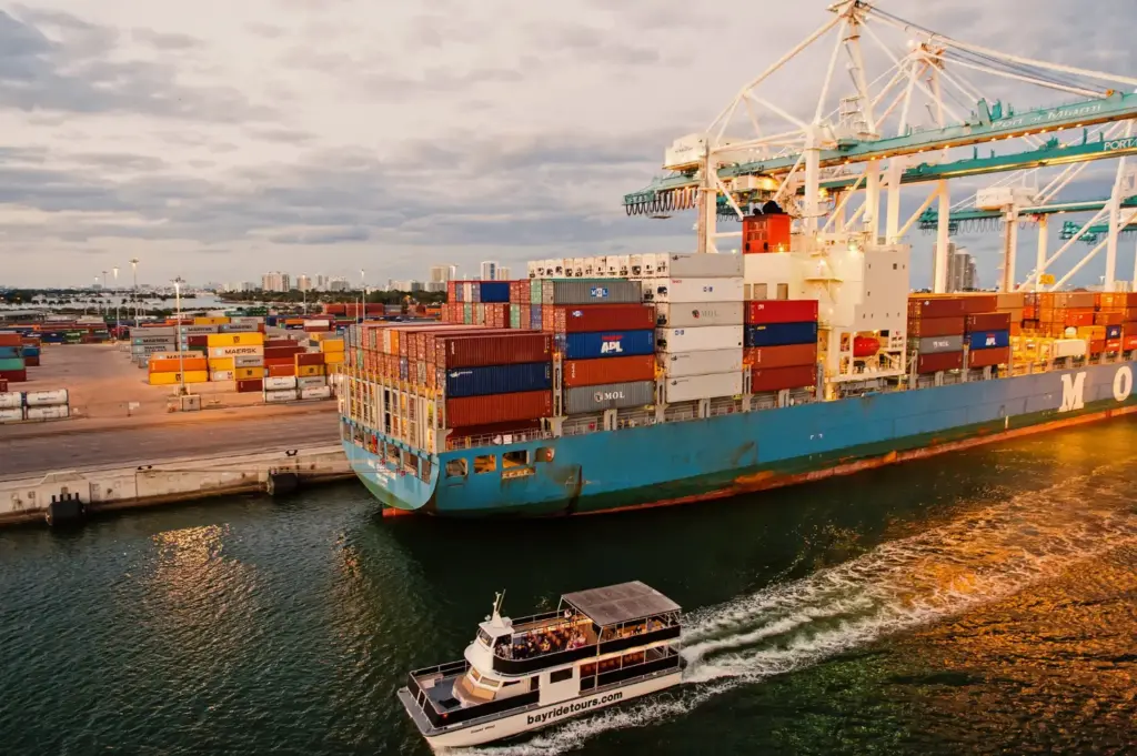 Navio porta-contêineres atracado em porto com guindastes, ilustrando o fluxo de importação direta e indireta no Brasil